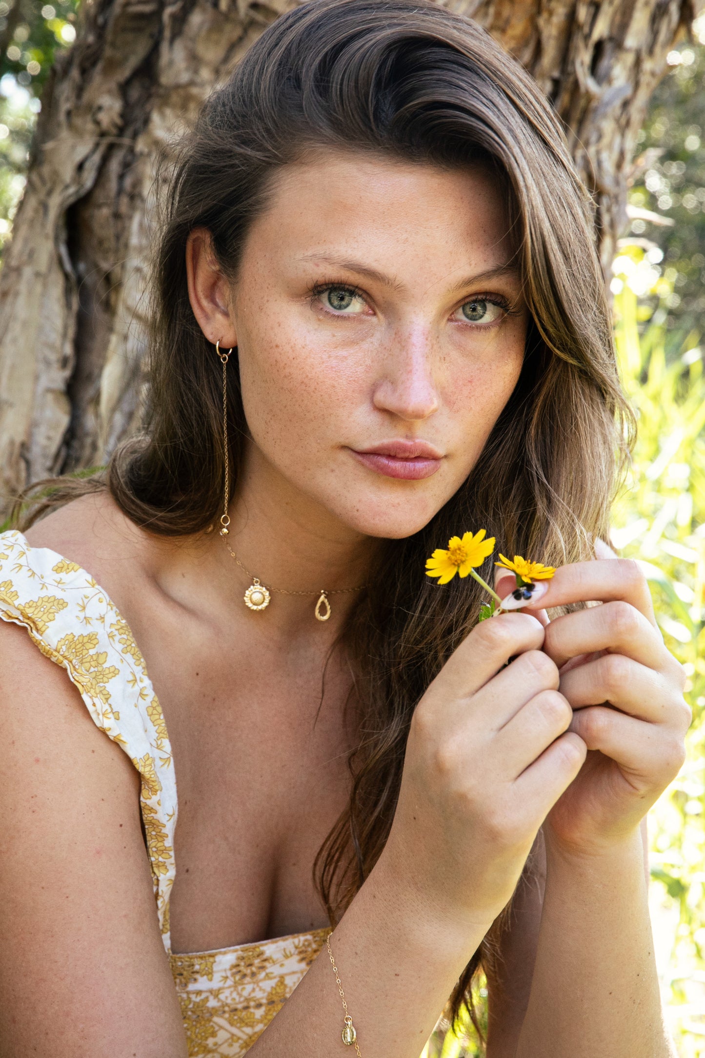 Woman wearing a golden necklace with sunflowers 